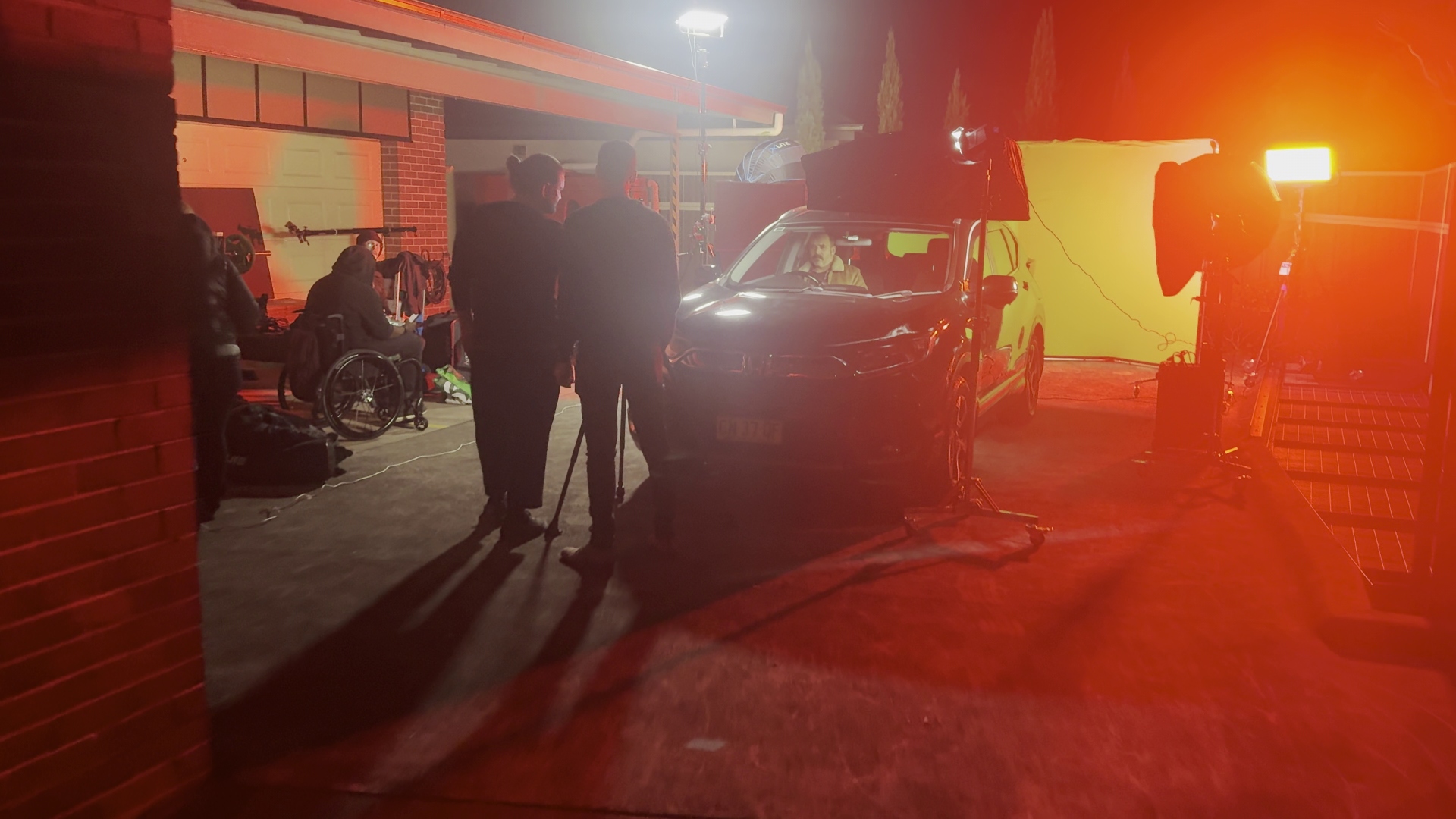 Crew on set at night, warm lighting